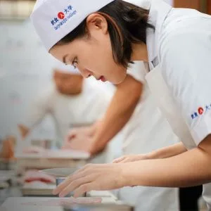 Student preparing sushi in JWC Academy's 3-month sushi master program